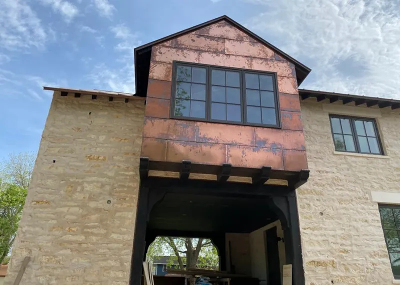 Copper metal panel facade on a stone building for Skylight Installation in Zachary